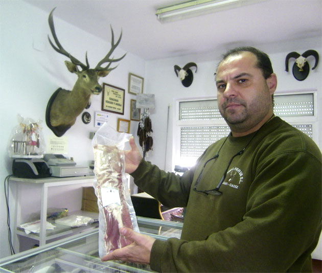 Uno de los hermanos Vallejo muestra la carne de caza envasada en su tienda de Algar. Foto: Cosasdecome