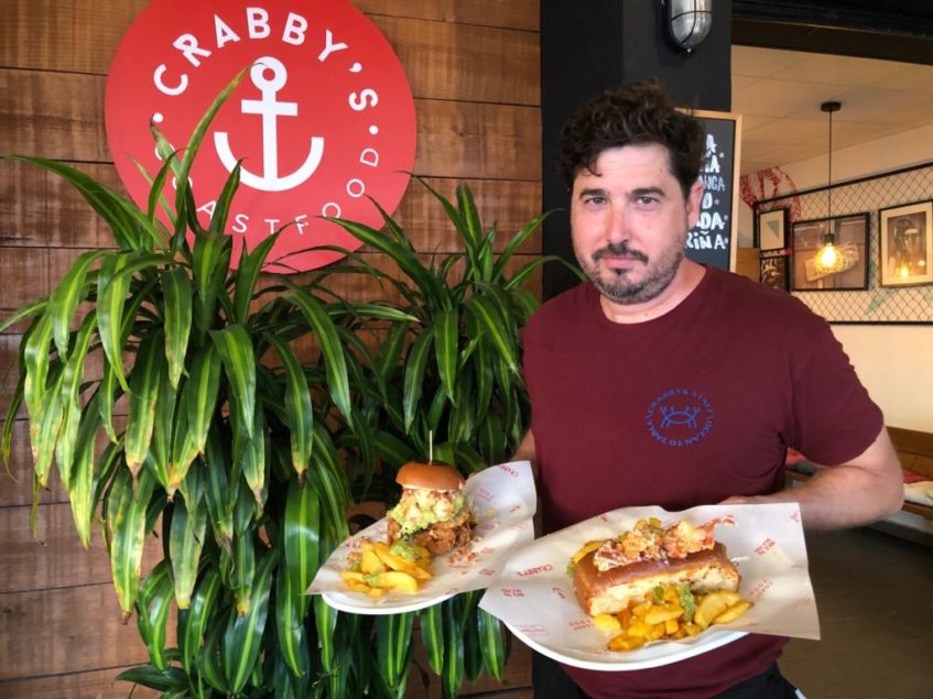 Carlos Juárez, propietario del establecimiento, posa junto al Crabby´s Burger y al perrito de bogavante. Foto: CosasDeComé 